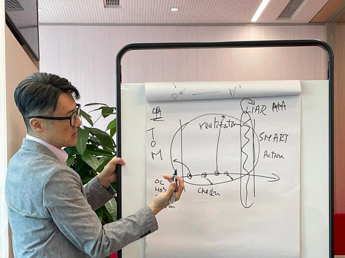 Colin Lee at a flip chart, mid-thought